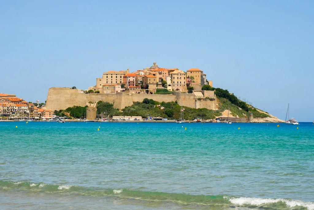 Vue sur la citadelle de Calvi et les remparts depuis la plage road trip en Corse